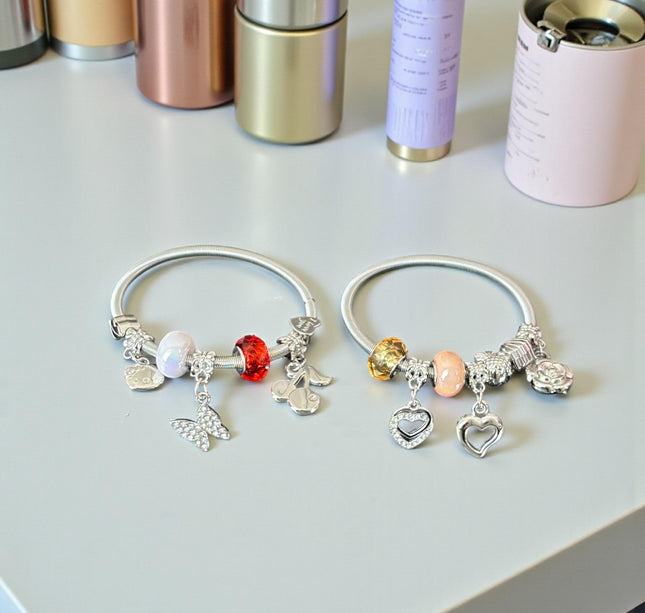 12 Pulseras Plateadas con Dijes tipo Pandora $13 c/u